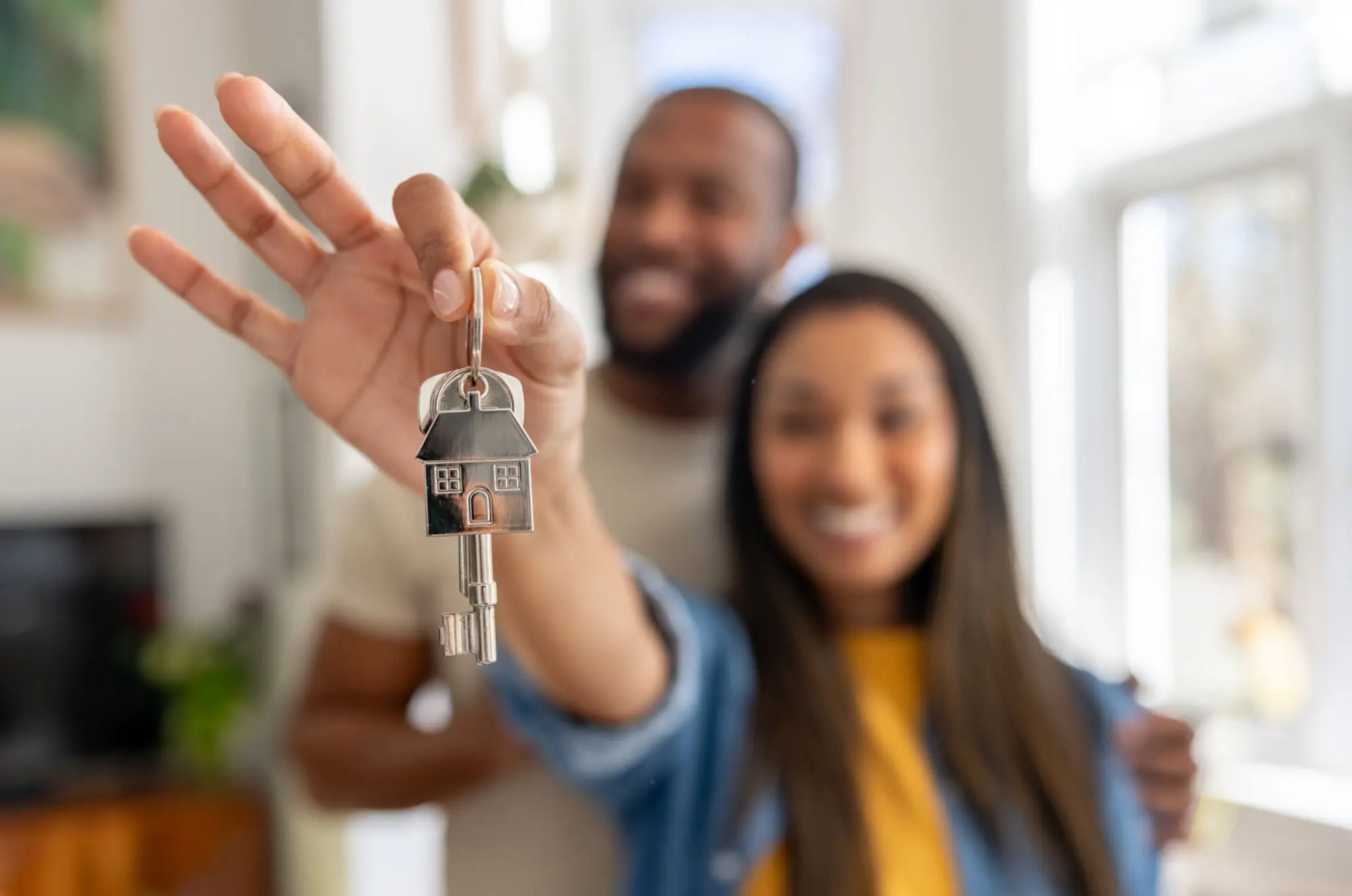 Happy couple showing new house keys, celebrating homeownership.